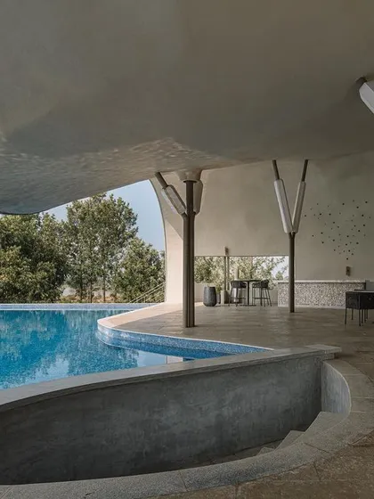 The interior of the Aqua Pool & Spa, showing how the curved concrete pool edge flows directly into the covered lounge space.
