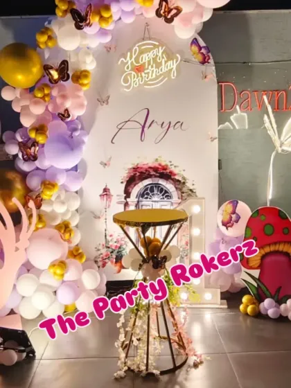 I designed this whimsical butterfly garden theme for a first birthday on a terrace. The setup includes a custom backdrop with a fairy door, mushroom cutouts, a light-up butterfly, and a pastel balloon arch.