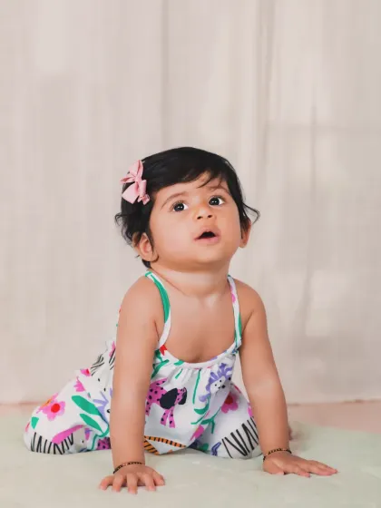 A simple, beautiful portrait of a baby girl on a plain background, showcasing her natural curiosity.