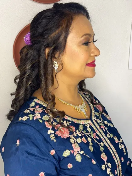 A side profile showing the soft curls and braided detail in her hair.