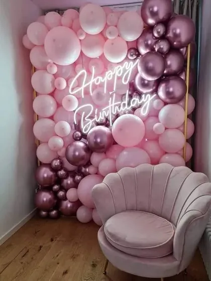 This full balloon wall is a fantastic photo opportunity for a birthday party. Created with shades of pink and metallic rose gold, it features an integrated neon sign and provides a luxurious, immersive backdrop for guests.