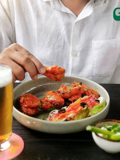 A classic pairing of spicy chicken wings and a cold beer. It's the perfect combination for a casual hangout or watching a game.
