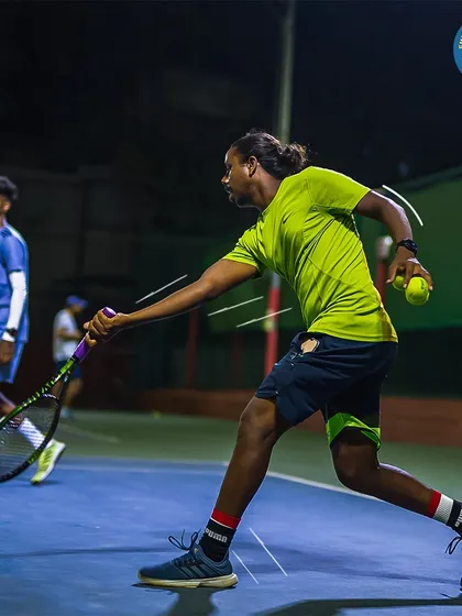 Unleash a powerful forehand on our pristine hard courts. This player is captured in a moment of pure focus and energy during a night session, showcasing our excellent court lighting.