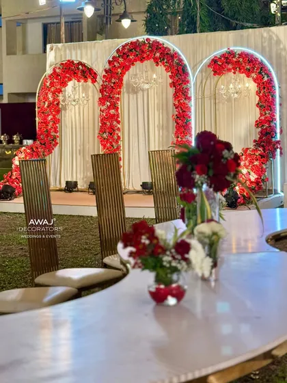 A view of the red rose photo booth from a modern, curved dining table, showing the integration of different event areas.