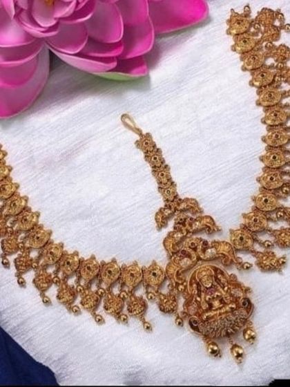 This is a three-piece matha patti, a more elaborate version of the maang tikka. It features a central pendant and two chains that go along the hairline, perfect for a bridal look.