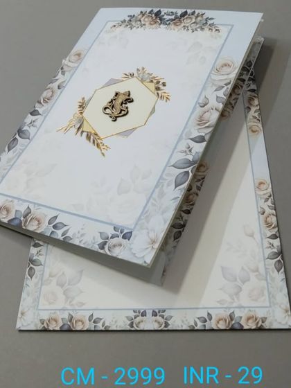 This vertical invitation has a soft blue background with a border of grey roses and a custom monogram. The design is elegant and understated.