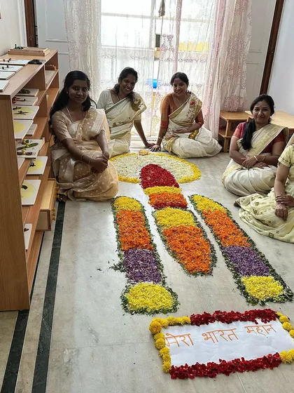 Our dedicated teachers, dressed in traditional sarees, celebrating the spirit of Onam with our unique floral creation.