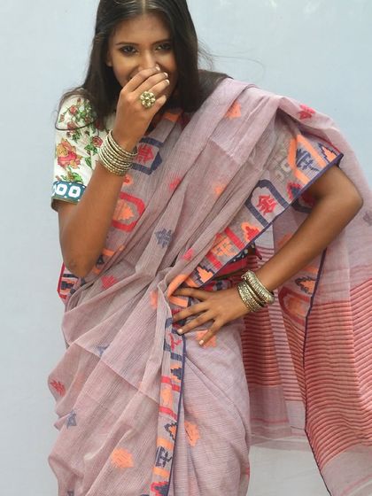 A playful moment in a beautiful handloom sari with a unique, modern border design, paired with a floral blouse.