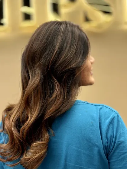 A side view of a client's hair with a beautiful ombré effect. The soft curls at the end enhance the color transition and add a touch of glamour.