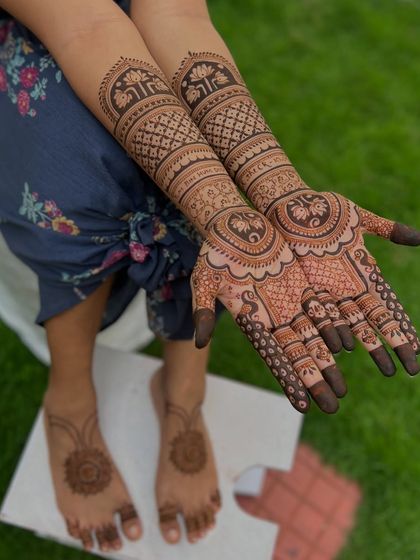 A full bridal package view, with detailed hand mehendi and a simpler, elegant mandala design on the feet.