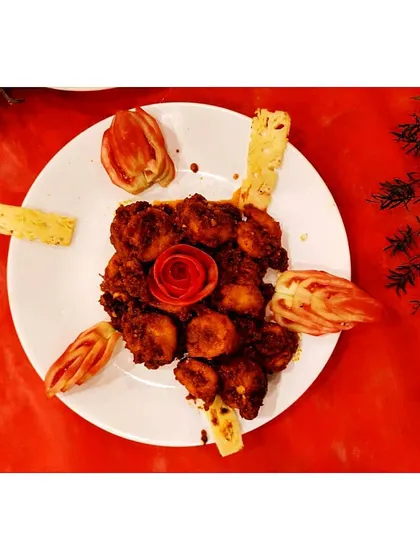 Every dish is prepared with care and plated beautifully. This platter of spicy fried prawns, garnished with a delicate tomato rose, shows our attention to detail in every single serving.
