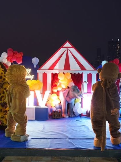 A magical evening performance with costumed characters and circus performers on a beautifully lit stage.