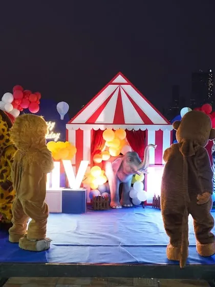 A magical evening performance with costumed characters and circus performers on a beautifully lit stage.