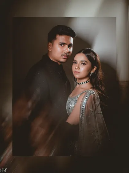 A striking, high-fashion portrait of the couple with dramatic lighting and a motion blur effect.