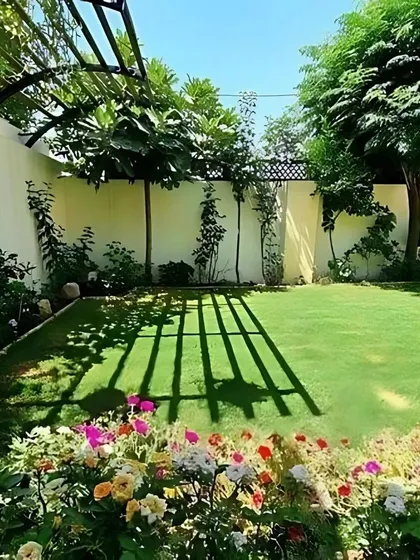 A perfect backyard retreat featuring a pristine lawn, a flower border with colorful roses, and a pergola casting beautiful shadows. This is the kind of idyllic outdoor living space we create.