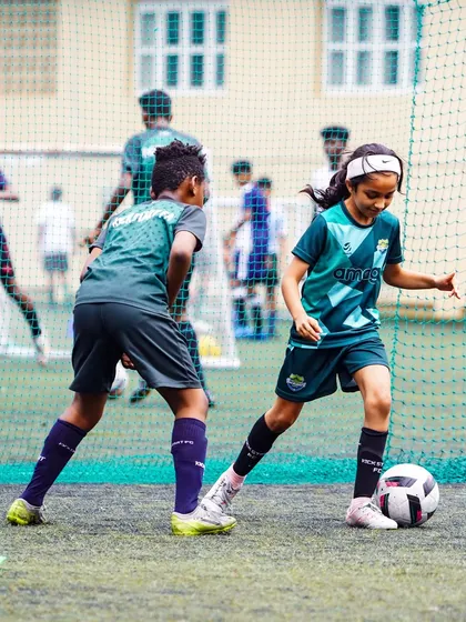 We are committed to developing talent in both boys and girls. This young player demonstrates focus and skill during a one-on-one drill, highlighting our inclusive and empowering training environment for all aspiring footballers.