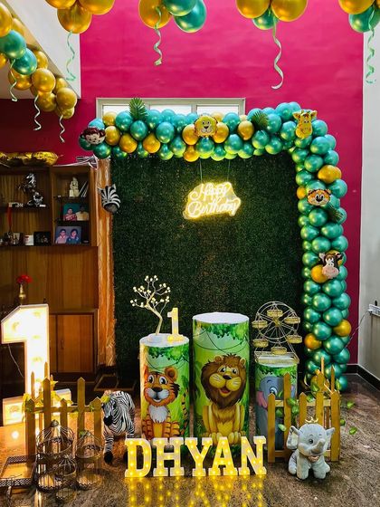Another view of the vibrant jungle safari first birthday decoration, showing the details of the animal-themed props and the gold and green balloon arrangement.