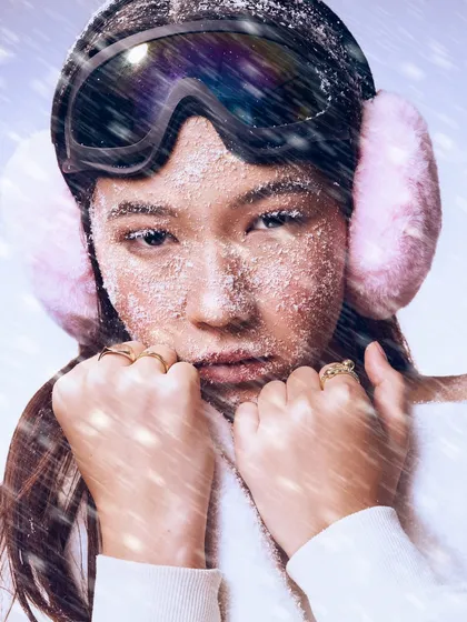 This shot captures the full "arctic vibe," with the ski goggles and earmuffs framing a face that is both fierce and beautifully frozen in time.