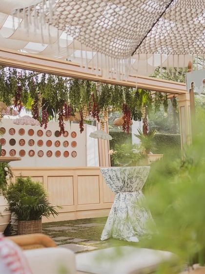 A bar area at the 'Farmers Market' brunch, with a canopy of hanging greenery and dried vegetables, reinforcing the rustic theme.