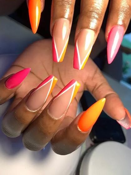 A vibrant neon design with orange and pink v-shaped French tips on long stiletto nails.