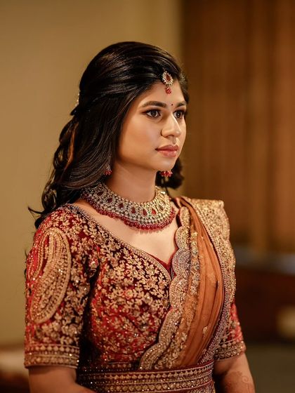 A side profile of the bride's reception look. The soft curls and the defined eye makeup create a glamorous and romantic silhouette.