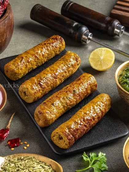 Mutton Seekh Kebab, presented with skewers. The styling for The Mughal House highlights the juicy texture and traditional preparation of this popular appetizer.
