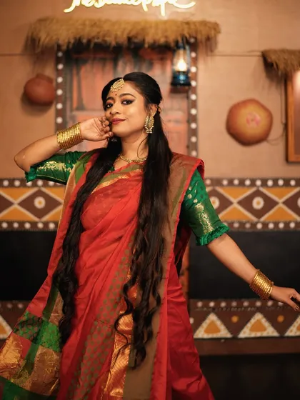 A full-length pose in the beautiful saree, with the rustic studio backdrop adding to the traditional feel.