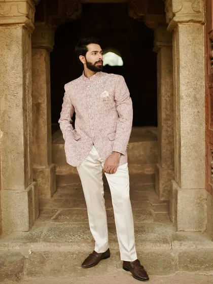 A client looking dapper in a pink floral Jodhpuri suit, embodying the essence of classic wedding menswear.