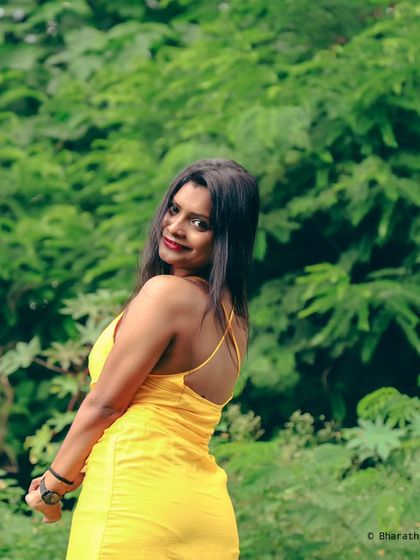 A happy and bright outdoor portrait. The smile and glance over the shoulder feel natural and full of life.