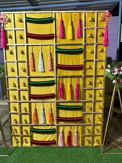 A wider view of the 'Bangla' function backdrop, flanked by modern floral stands that complement the traditional design.