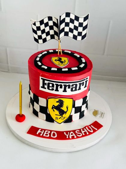 A sleek Ferrari-themed cake in iconic red, with checkered flags and the prancing horse logo.