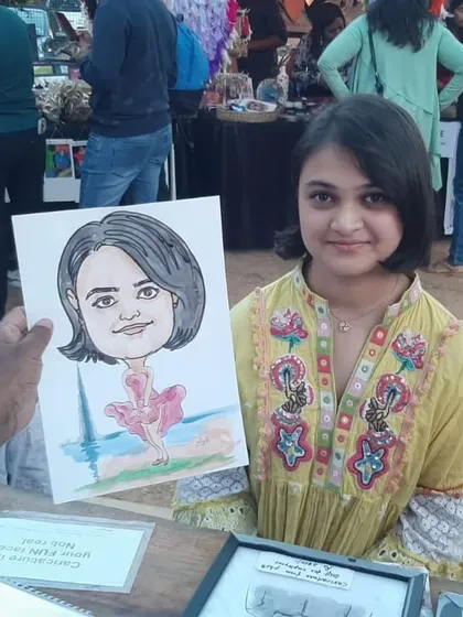 This young lady is showing off her ballerina-themed caricature from the "Ten Thousand Treasures" market event in Bangalore.