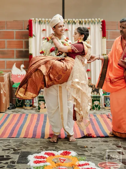 A candid moment of the groom carrying his bride, a beautiful display of love and happiness right after the main ceremony. This is the kind of unscripted joy we aim to document.