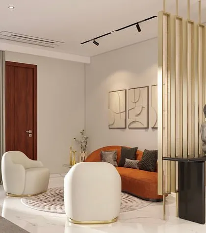 A view of the foyer area adjacent to the living room, featuring a serene Buddha sculpture and a small, vibrant seating nook. The gold-toned vertical partition provides a sense of separation while maintaining an open and airy feel.