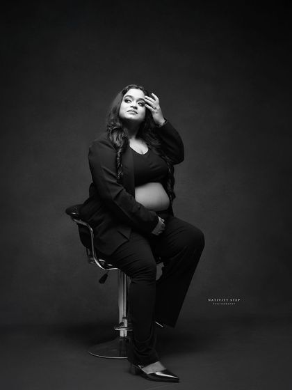 A classic and fashionable black and white pose. The lighting and expression give this portrait a timeless, magazine-quality feel.