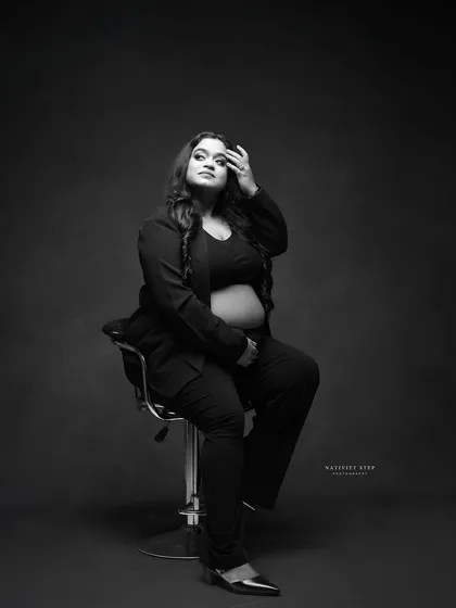 A classic and fashionable black and white pose. The lighting and expression give this portrait a timeless, magazine-quality feel.