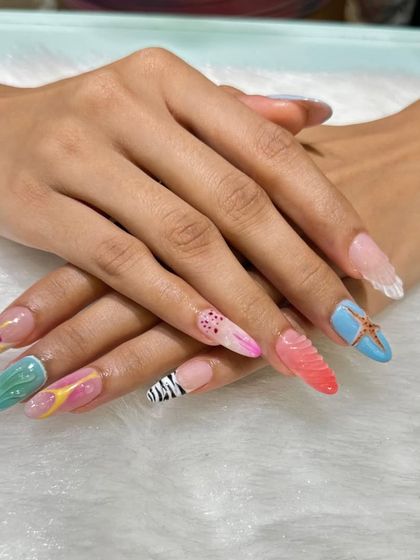 A true work of art where every nail is different. This long, stiletto set features a mix of textures and designs, including 3D shells, zebra print, floral art, and bright colors for a maximalist, creative look.