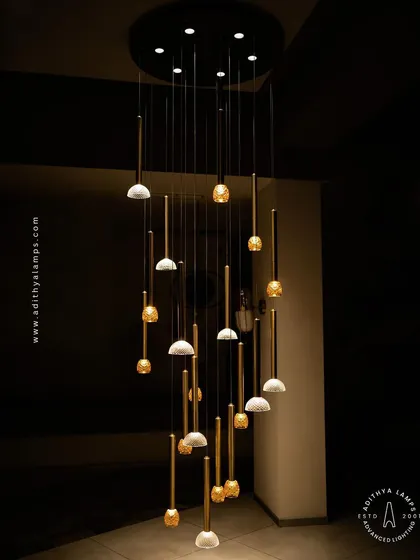 This multi-pendant chandelier combines textured glass and polished brass rods to create a stunning visual effect. It is ideal for stairwells or rooms with high ceilings, where its staggered design can be fully appreciated.