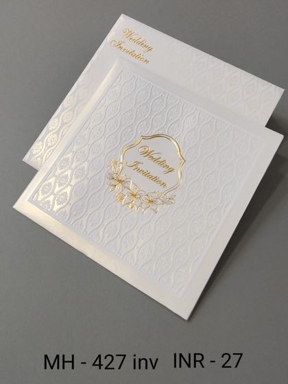 A very affordable and minimalist white invitation with a textured pattern and a simple gold emblem. This card proves that elegance doesn't have to be expensive.