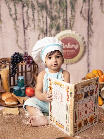 This little chef is studying his cookbook, getting ready to bake something delicious. The attention to detail in my props helps create a believable and engaging story.