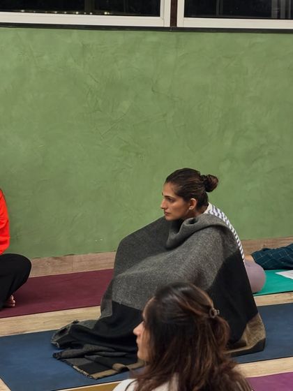 Finding warmth and stillness. A participant wrapped in a blanket during a deep rest session, embodying the comfort and peace we cultivate in our workshops.