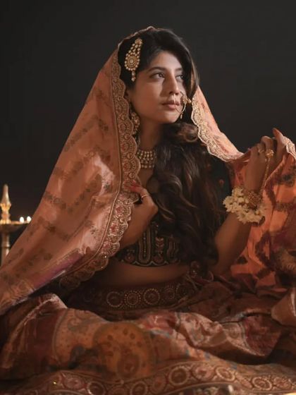 Create a dramatic and timeless bridal portrait with our collection. This Heeramandi-inspired lehenga with its rich fabric and traditional motifs is perfect for a classic look.