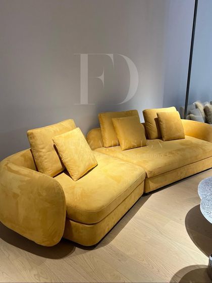 A stunning L-shaped sectional in a bright, sunny yellow. The curved design and plush cushions make it an incredibly inviting centerpiece, perfect for bringing warmth and modern style to a large living area.