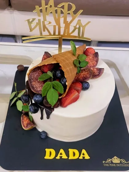 A unique take on a fruit cake, with a waffle cone spilling fresh figs, blueberries, and strawberries over the top.