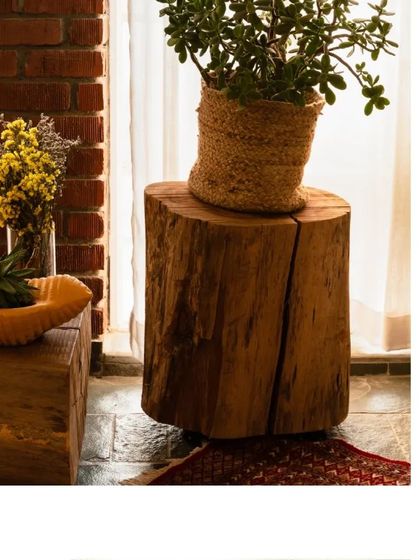 We use repurposed wood in many forms, like this solid eucalyptus log that serves as a rustic side table, bringing a piece of the outdoors in.
