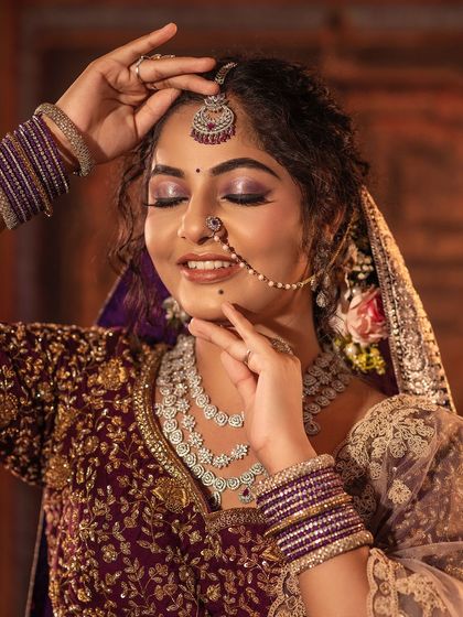 A close-up of the bridal look, showing the detailed makeup and the intricate embroidery on the blouse. The maang tikka and nose ring complete the traditional North Indian bridal look.