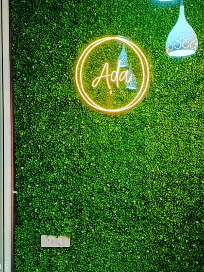 I can incorporate your company's branding directly into the design. This green wall for a commercial space features a custom neon logo, making it a great backdrop for a reception or entrance area.