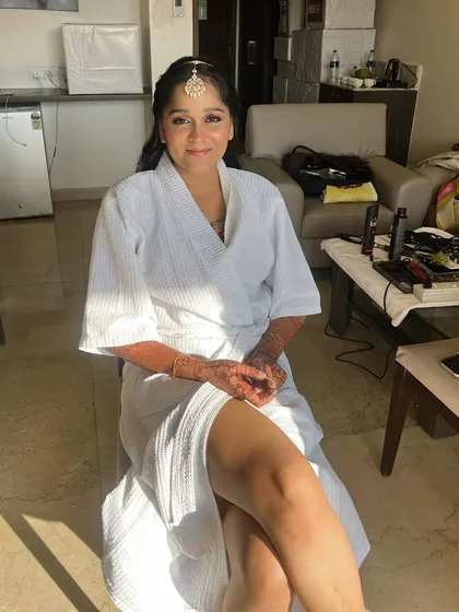 A before-makeup shot, showing the bride's sister ready and excited for her transformation.