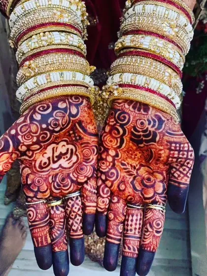 The deep, dark stain on this bride's hands, with her groom's name 'Farhan' clearly visible.