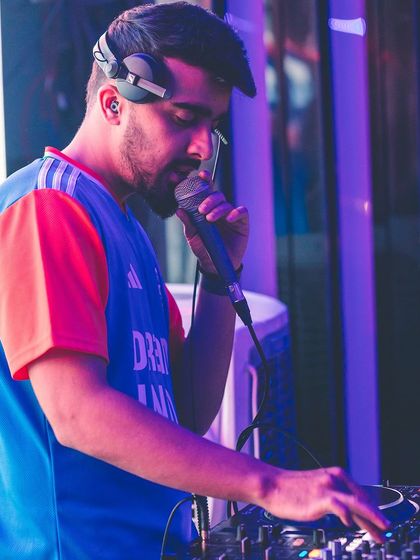 On the mic, guiding the crowd through the musical journey. I use my voice to connect and direct the energy of the room.